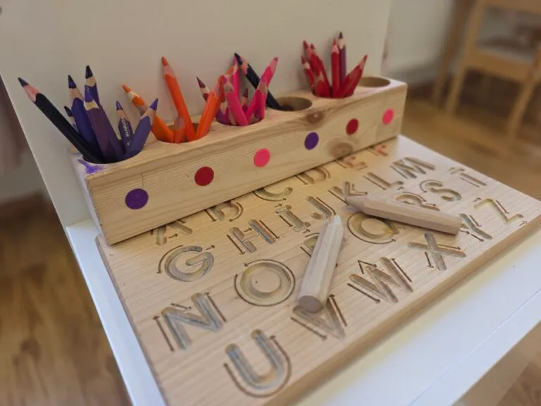 A wooden alphabet tracing board and coloured pencils for practising writing